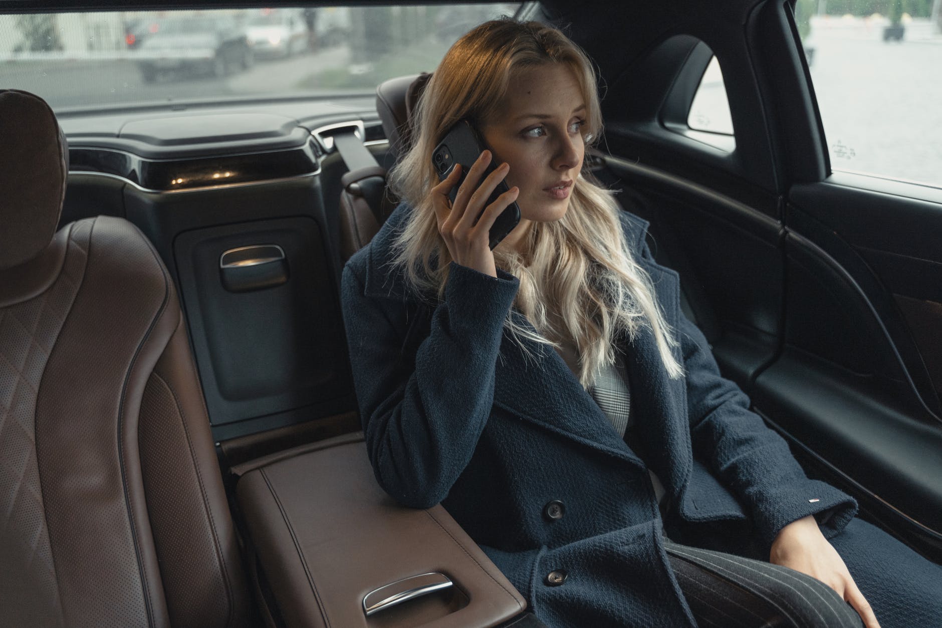 woman wearing a coat sitting inside a car